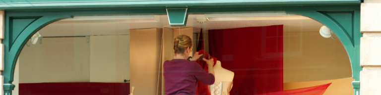 Mujer trabajando en un escaparate con maniquí